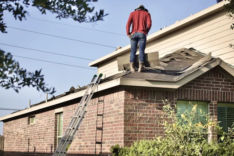 Professional roofer working on a residential roof in Aldine